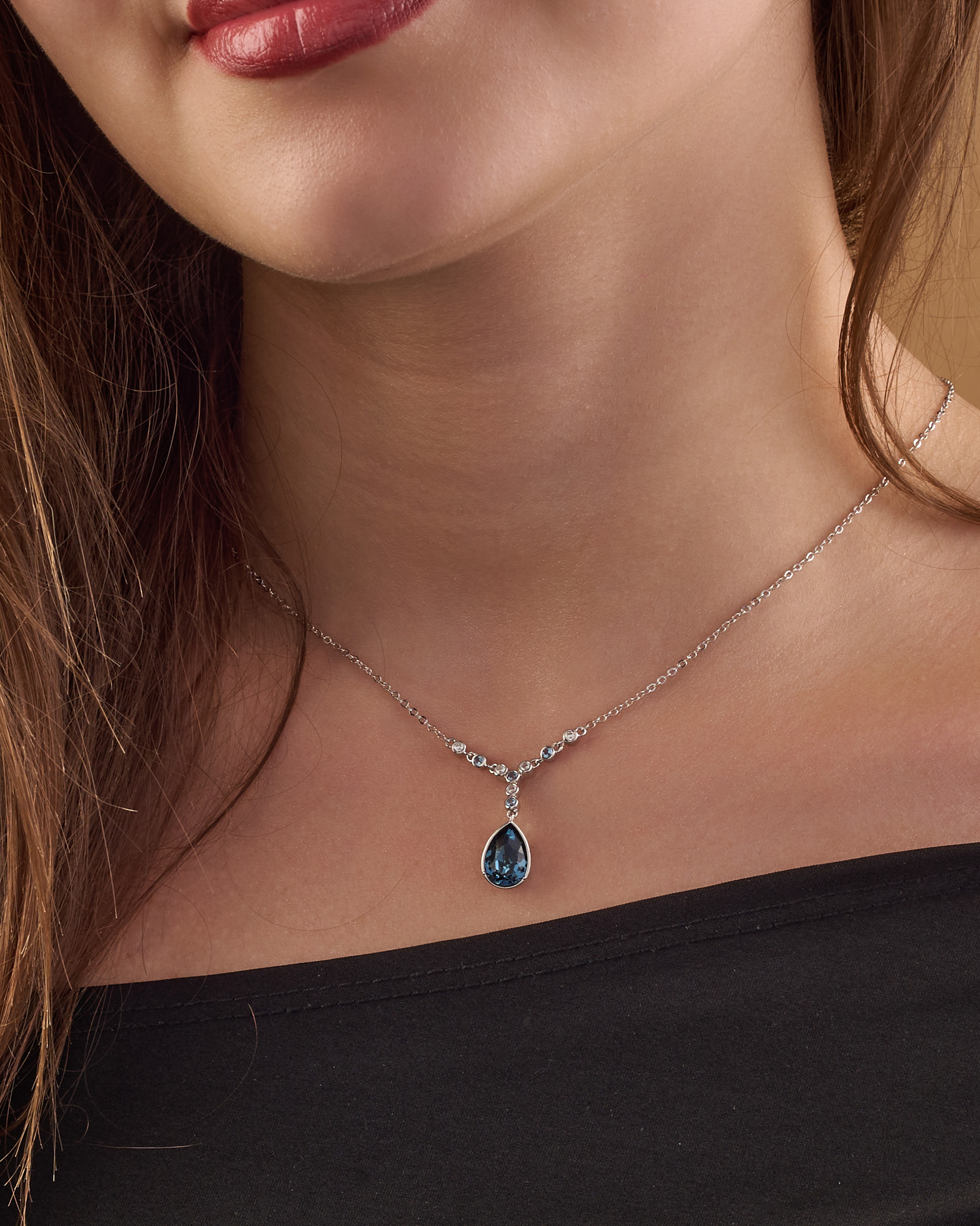 A silver necklace in the shape of a water drop, inlaid with Blue zircon stones.