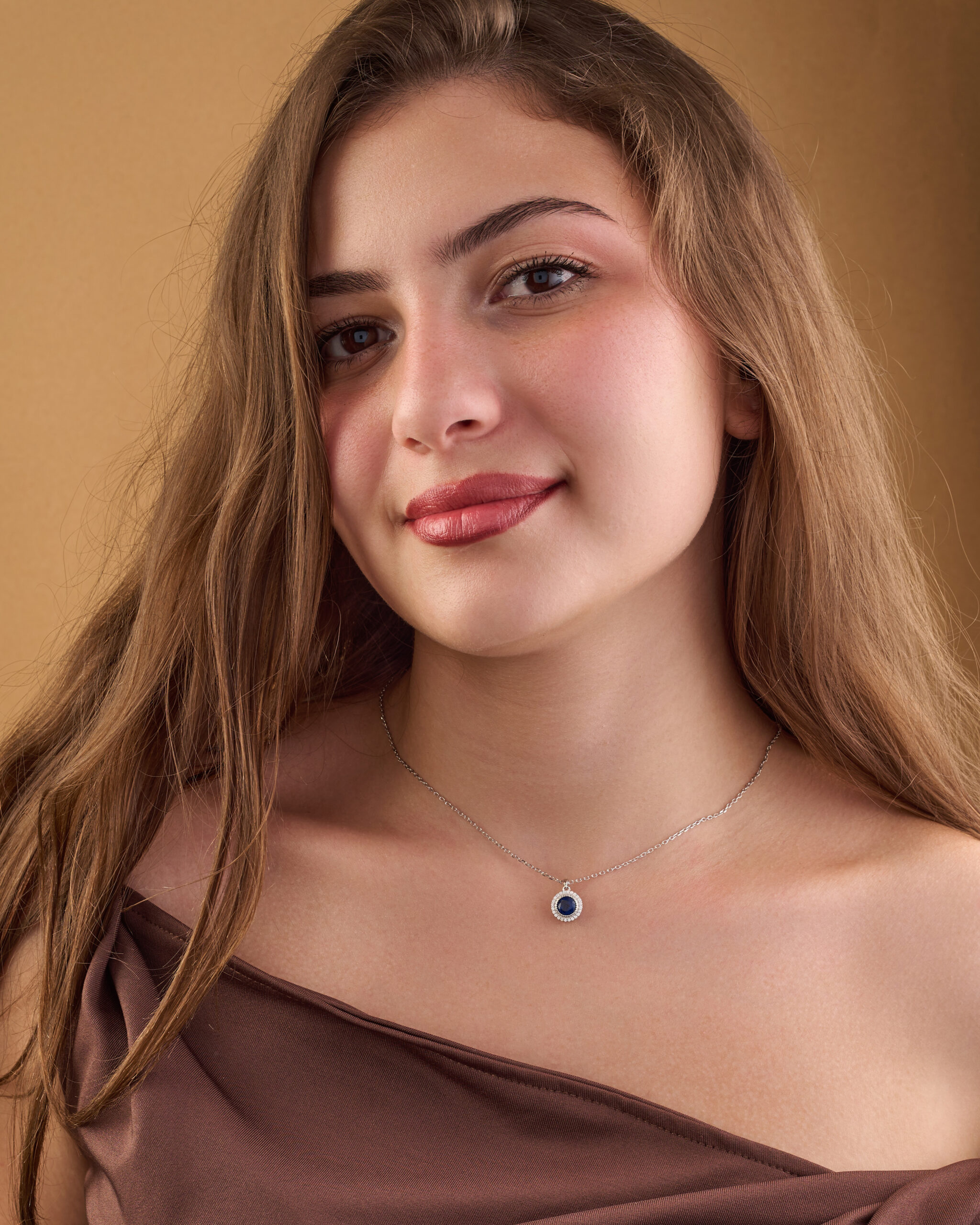 Simple silver pendant in the shape of a circle, inlaid with white zircon and blue sapphire stones. - Image 2